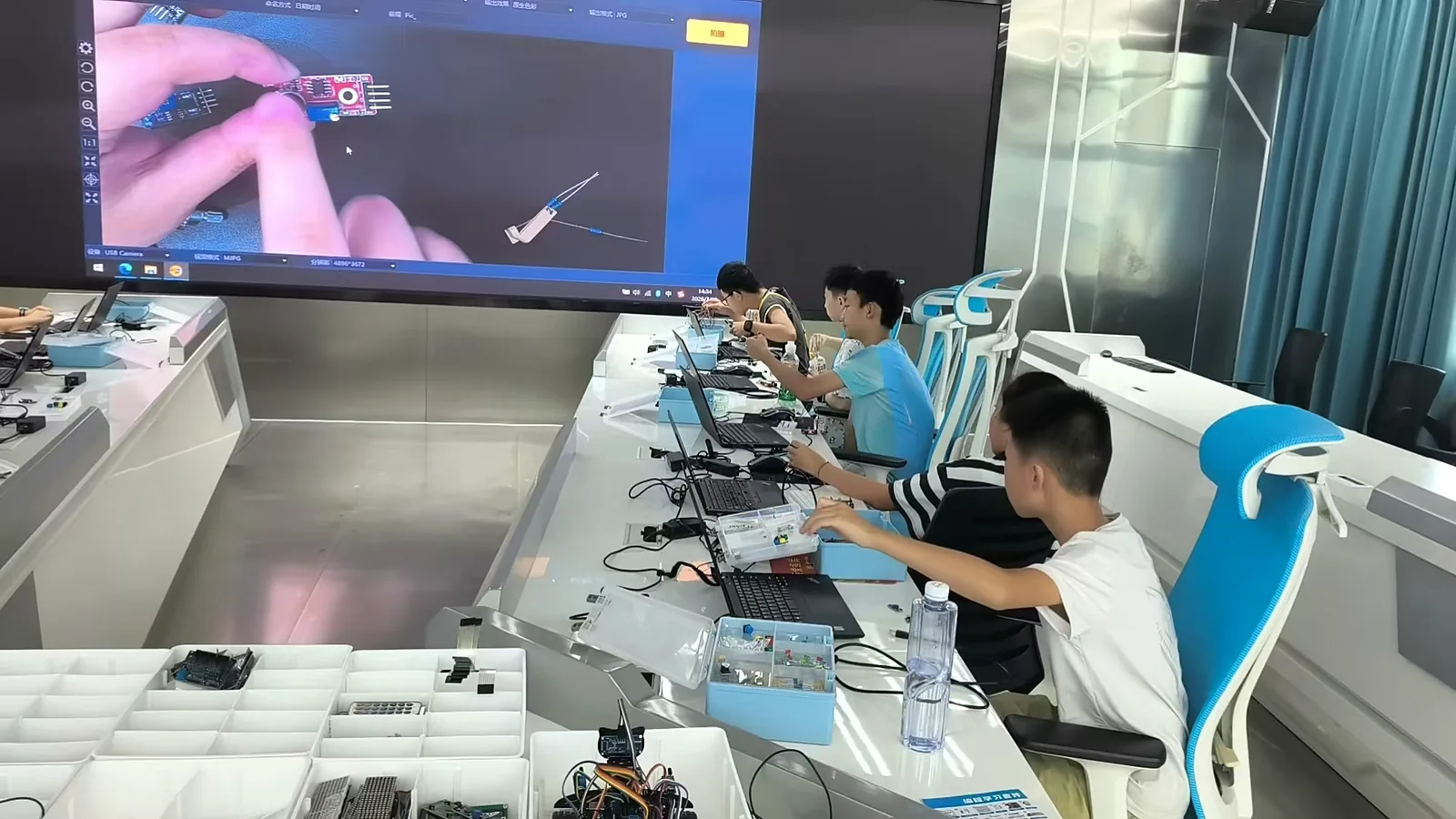 教师通过大屏讲解智能硬件操作，学生同步实践